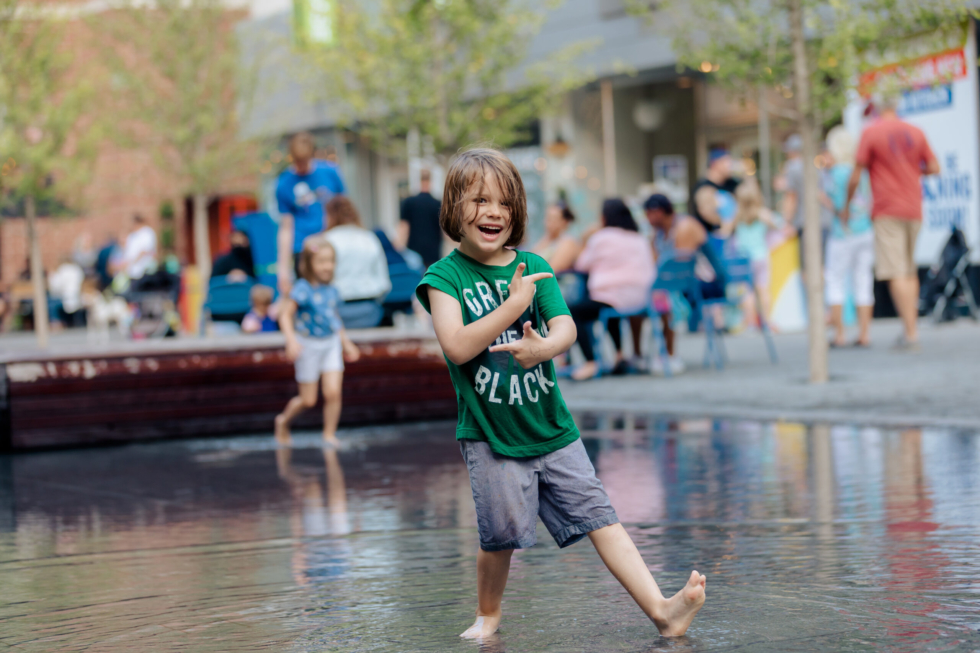 A child plays in the water feature at Peace Plaza in the Heart of the City, Rochester, MN